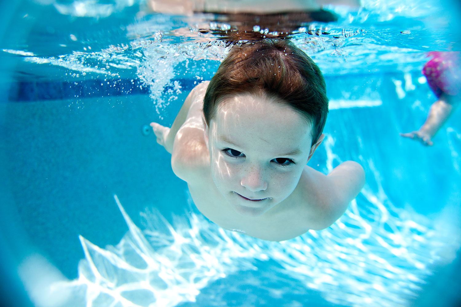 Kind taucht unter Wasser ohne Schwimmbrille